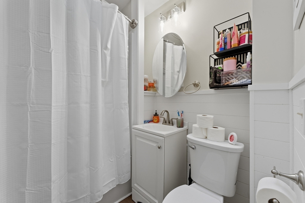 24 Elm Street Ludlow, MA 01056 - Photo 26 of 39 a bathroom with a toilet a sink and a shower curtain