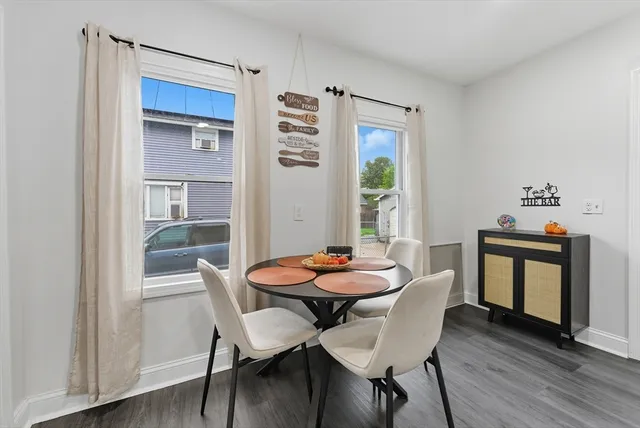 a dining room with furniture window and wooden floor