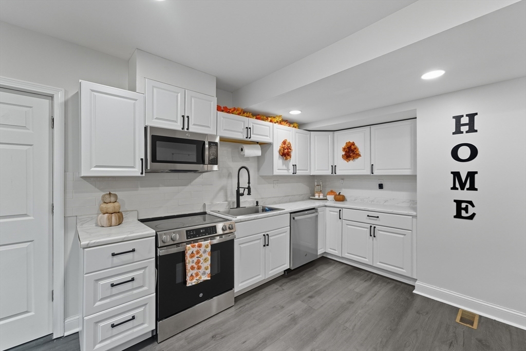 24 Elm Street Ludlow, MA 01056 - Photo 6 of 39 a kitchen with white cabinets and white appliances