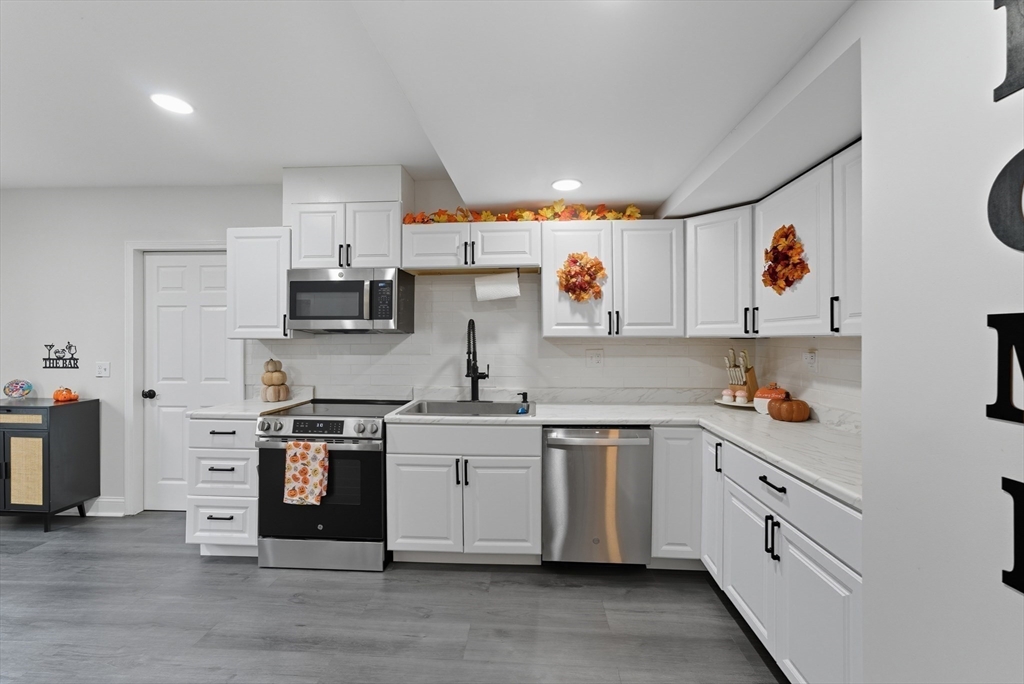 24 Elm Street Ludlow, MA 01056 - Photo 8 of 39 a kitchen with stainless steel appliances granite countertop a stove and white cabinets