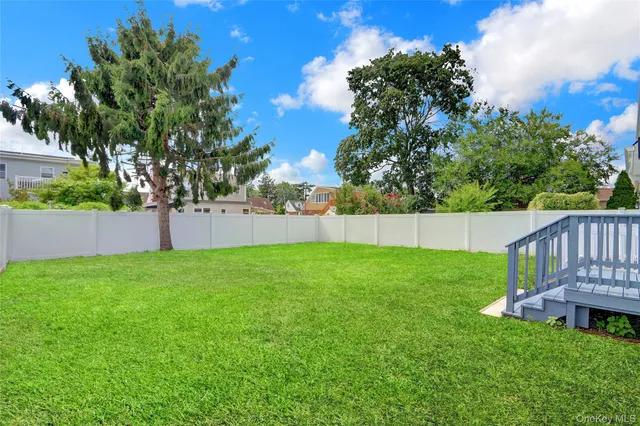 a view of a yard with a fence and a tree