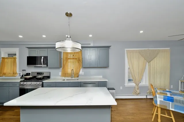 a kitchen with stainless steel appliances granite countertop a sink a stove and a microwave