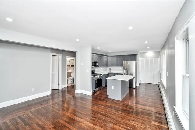 a view of kitchen with a sink and dishwasher a oven with wooden floor