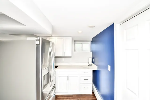 a kitchen with a refrigerator sink and cabinets