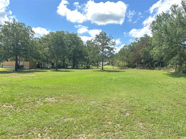 a front view of a house with a garden and trees