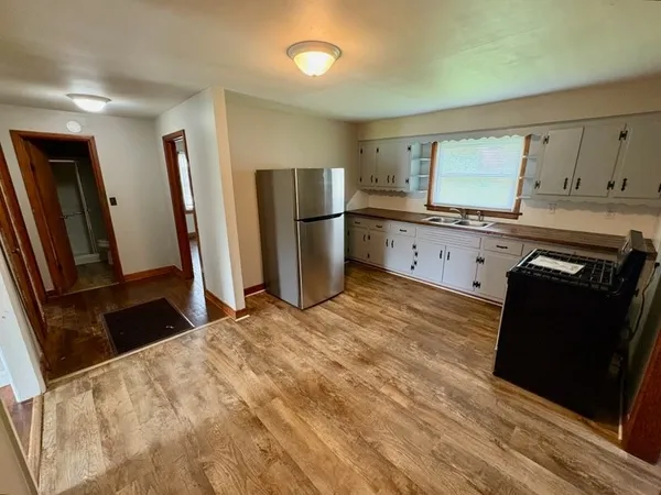 a kitchen with granite countertop a refrigerator stove and sink