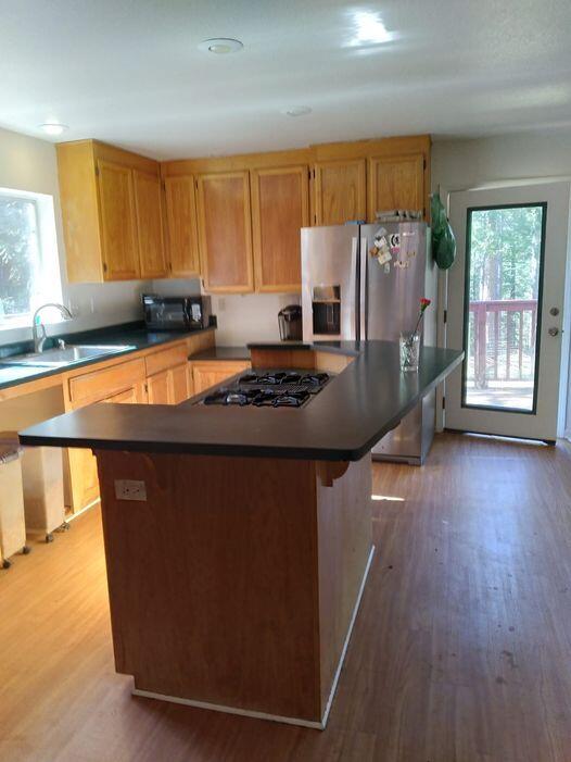 14966 Phillips Road Oak Run, CA 96069 - Photo 4 of 5 a kitchen with stainless steel appliances granite countertop a refrigerator a stove a sink and dishwasher with wooden floor