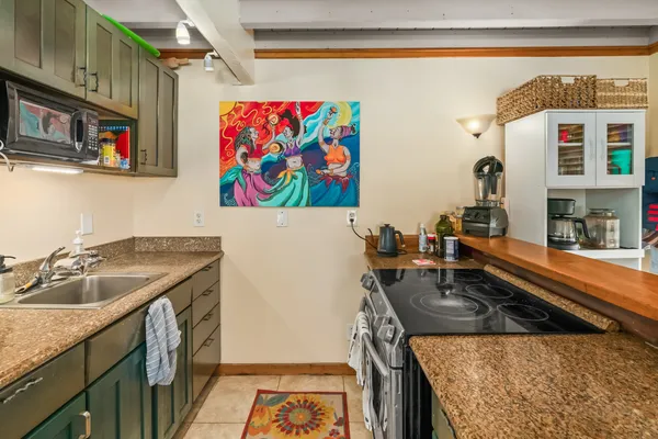 a utility room with stainless steel appliances granite countertop a sink and a stove