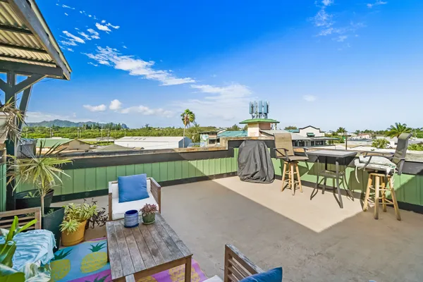 a view of a terrace with furniture and a garden