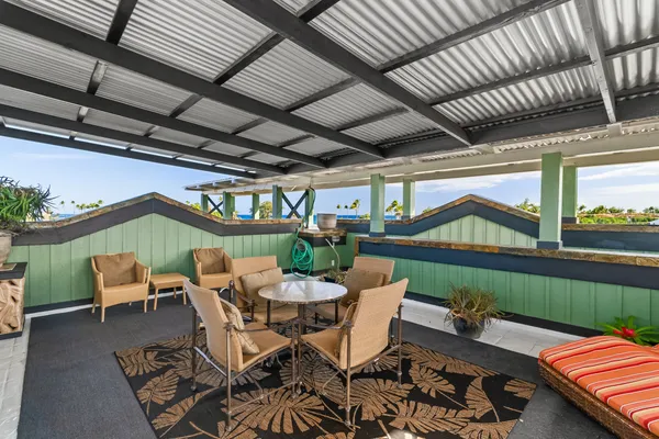 a view of a chairs and table in patio with a barbeque