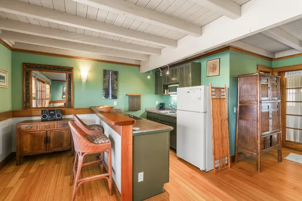 a dining hall with stainless steel appliances granite countertop a refrigerator and a stove top oven