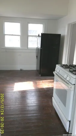 a kitchen with granite countertop white cabinets and wooden floor