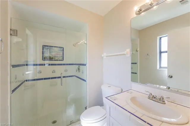 a bathroom with a sink mirror vanity and toilet
