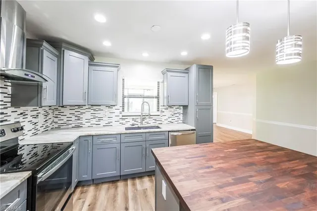 a kitchen with kitchen island granite countertop a sink stove and refrigerator