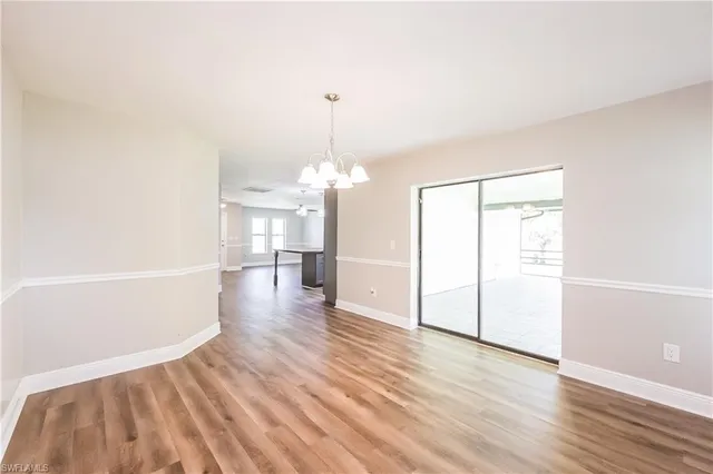 a view of a room with wooden floor staircase and a kitchen
