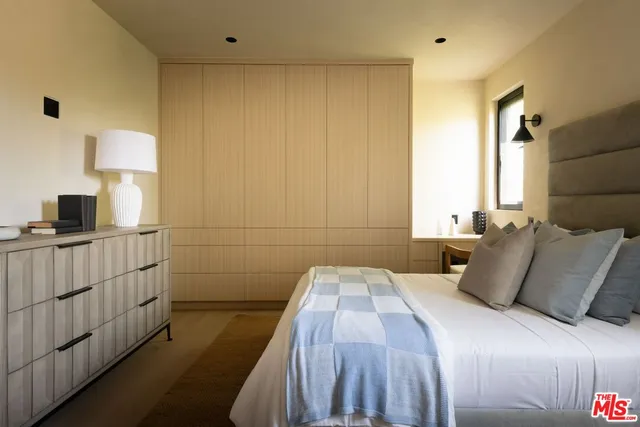 a bedroom with bed and a large window