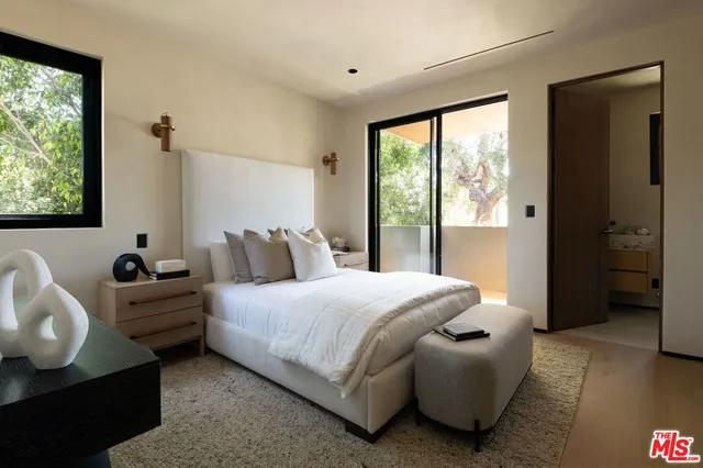 a view of a bedroom with a table and chair in it