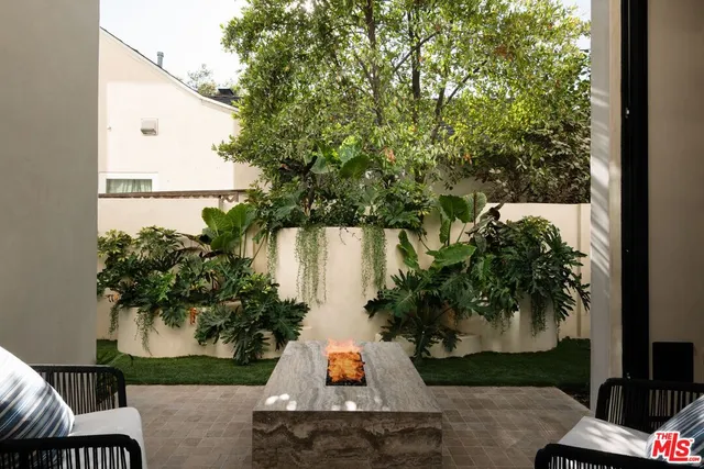 a view of a patio with table and chairs and potted plants