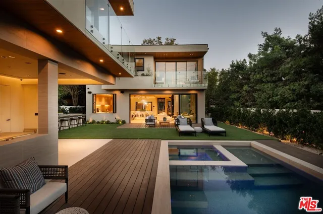 a view of a patio with table and chairs potted plants and floor to ceiling window