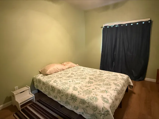 a bedroom with a bed and wooden floor