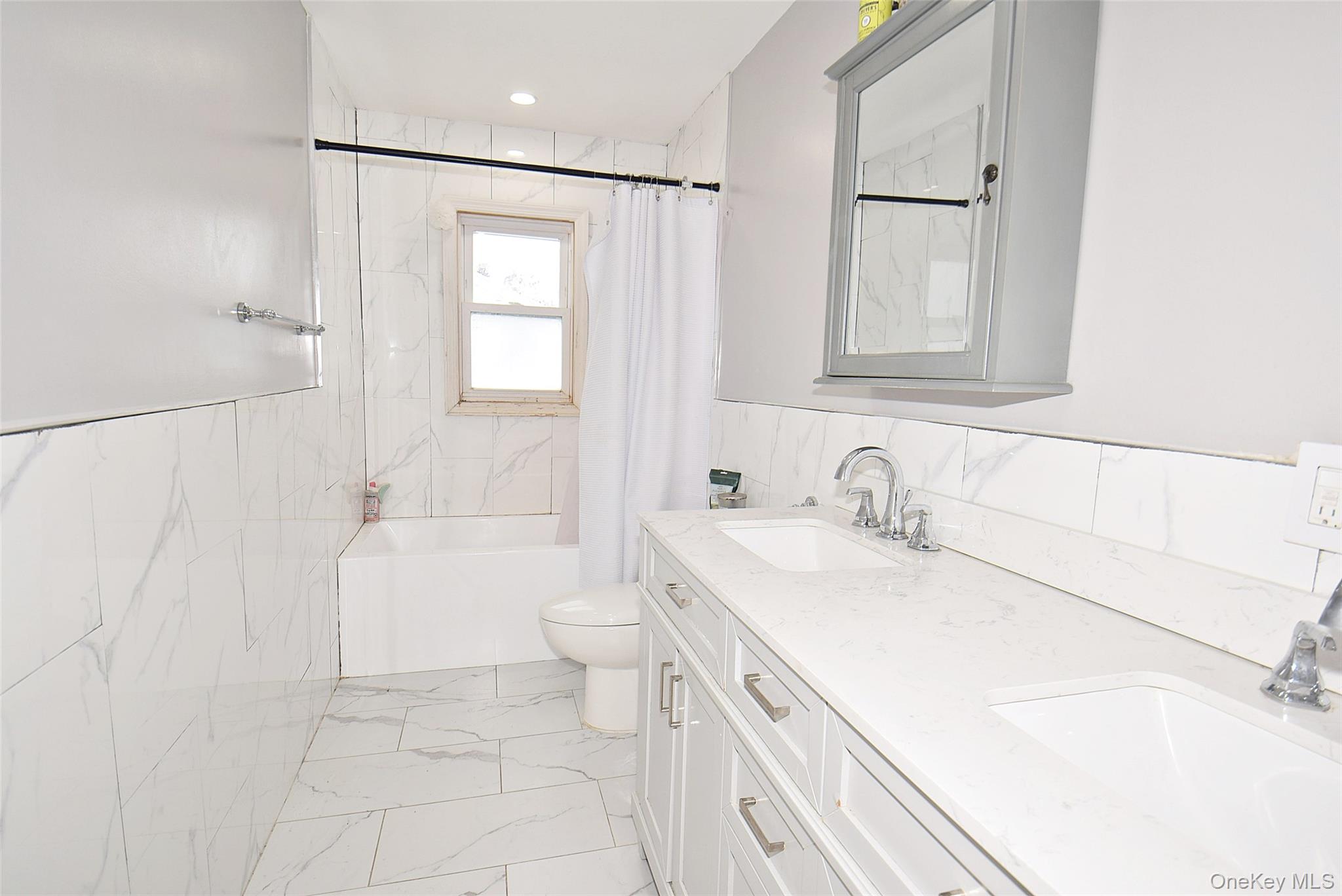3029 Ann Street Baldwin, NY 11510 - Photo 14 of 26 a bathroom with a sink toilet vanity and tub