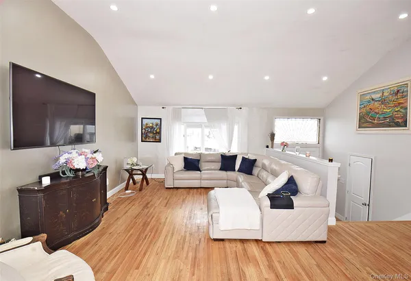 a living room with furniture a flat screen tv and wooden floor