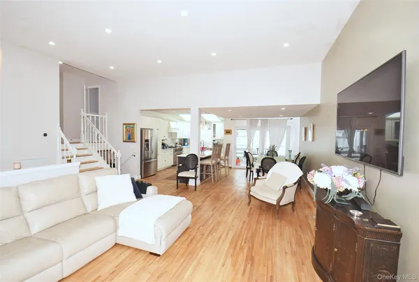 a large kitchen with stainless steel appliances a refrigerator a stove a sink dishwasher a oven with white cabinets and wooden floor