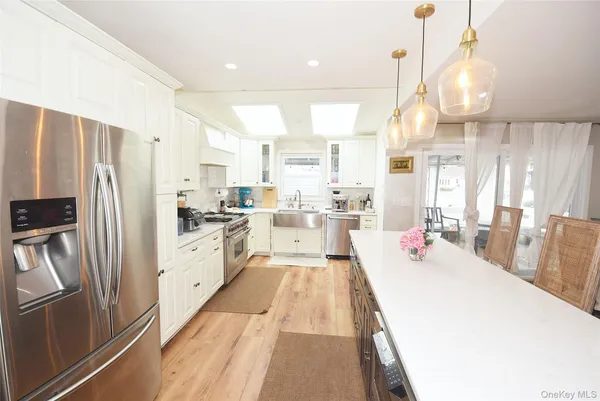a large kitchen with stainless steel appliances lots of counter space and wooden floor