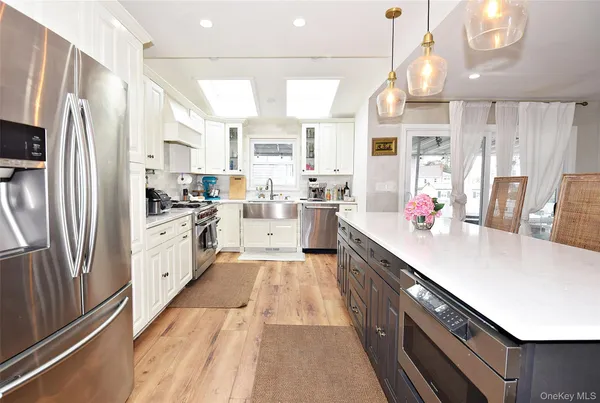 a kitchen with white cabinets white appliances and sink
