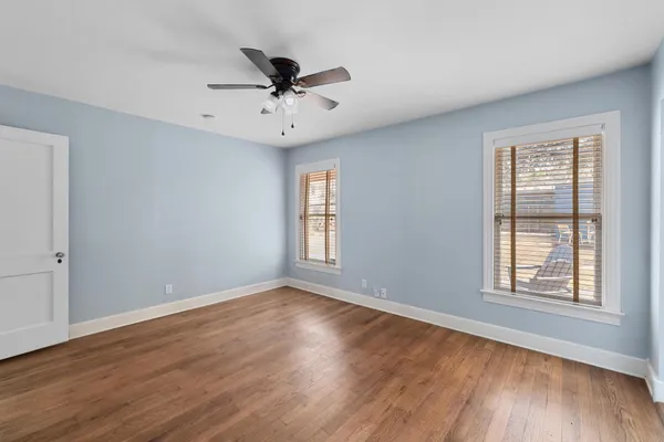 a view of a big room with wooden floor and windows
