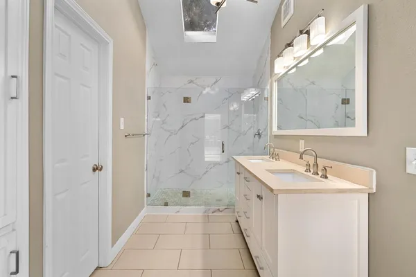 a bathroom with a sink a mirror and a shower