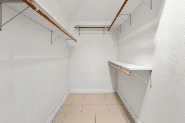 a view of walk in closet with empty racks