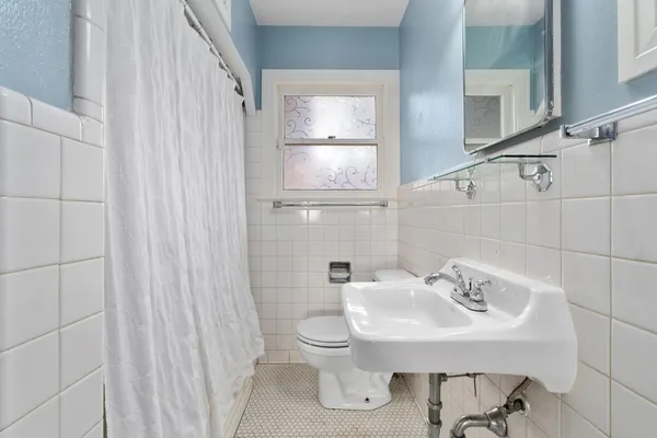 a bathroom with a sink toilet and mirror