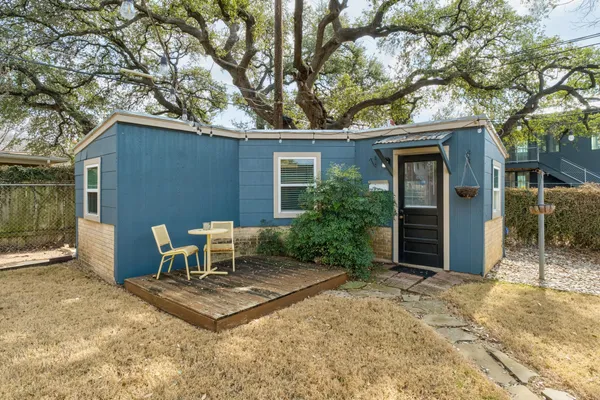 a view of a chair and table in backyard of the house