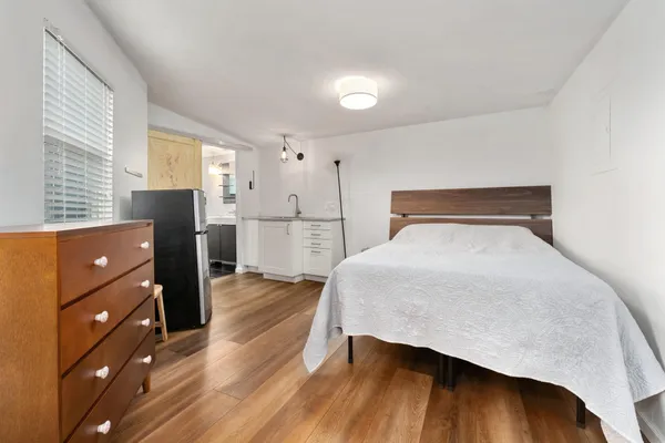 a bedroom with a bed and wooden floor