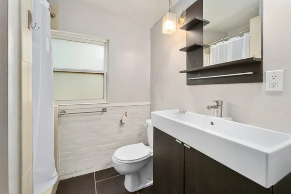 a bathroom with a sink a toilet and mirror