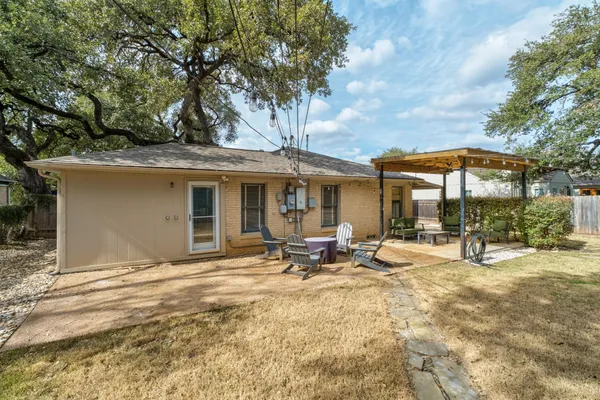 a view of a house with backyard and sitting area