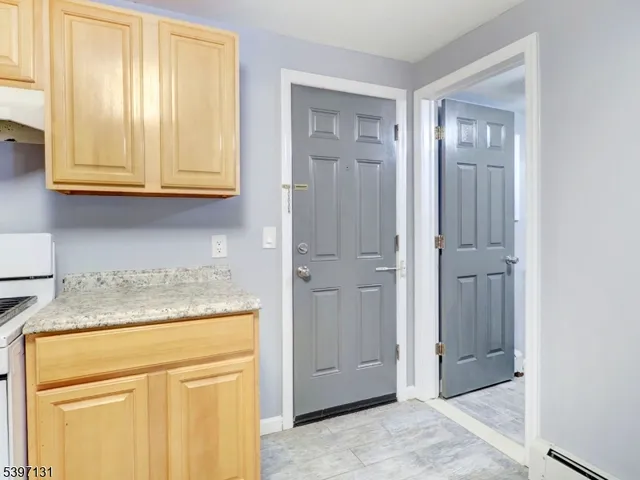 a kitchen with granite countertop cabinets stainless steel appliances and a wooden floor