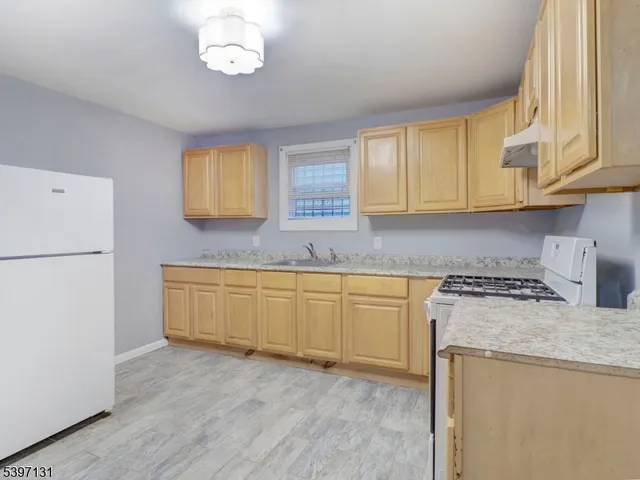 a kitchen with granite countertop white cabinets sink and white appliances