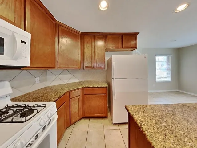 a kitchen with stainless steel appliances granite countertop a refrigerator and a stove