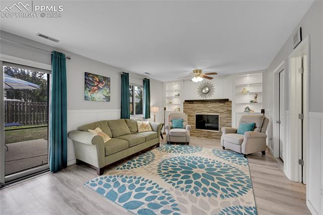 5255 Pinon Valley Road Colorado Springs, CO 80919 - Photo 14 of 47 Living room featuring built in features, plenty of natural light, and light hardwood / wood-style floors