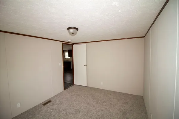 a view of a backyard with large trees and a barn