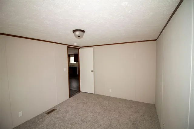 a view of a backyard with large trees and a barn