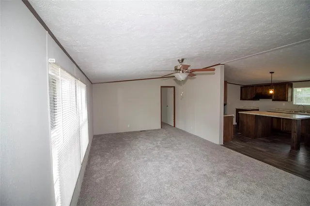 a view of an empty room with a fireplace and a window