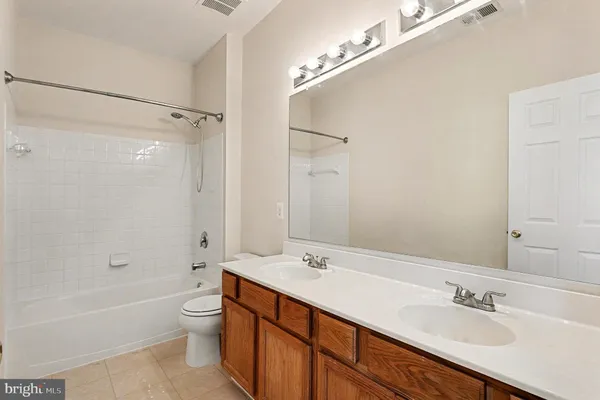 a bathroom with a double vanity sink mirror and toilet