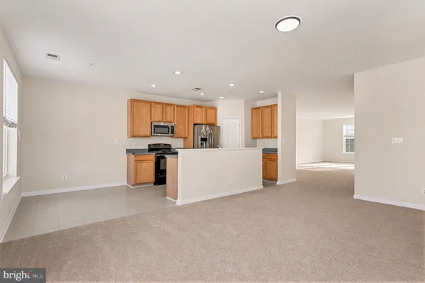 a view of a kitchen with refrigerator and a sink