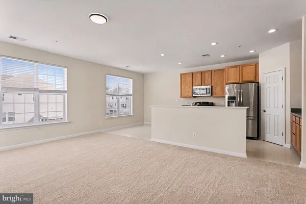 a view of kitchen with stainless steel appliances refrigerator stove microwave and cabinets