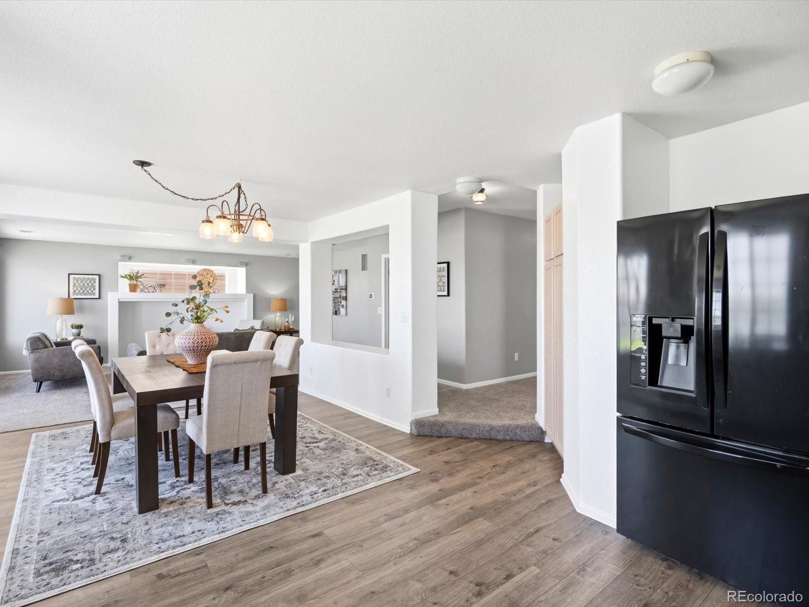 5444 Perth Court Denver, CO 80249 - Photo 11 of 46 a view of a dining room with furniture a rug and wooden floor