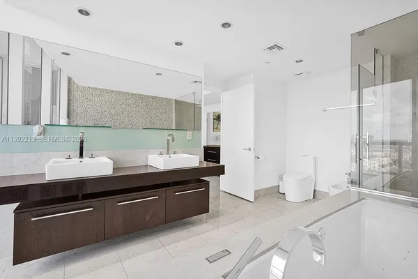 a spacious bathroom with a bathtub shower sink and toilet
