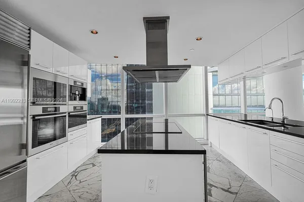 a kitchen with stainless steel appliances granite countertop a refrigerator and a sink
